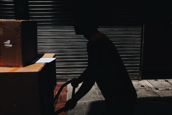Shadowy figure stealing cargo from a storage unit