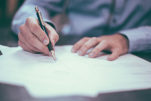 recruiter sitting at a desk writing notes on a resume 