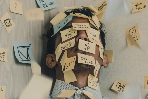 Male employee with sticky notes covering his face