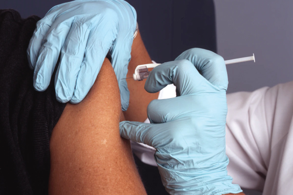 Nurse injecting vaccine into an employee’s arm